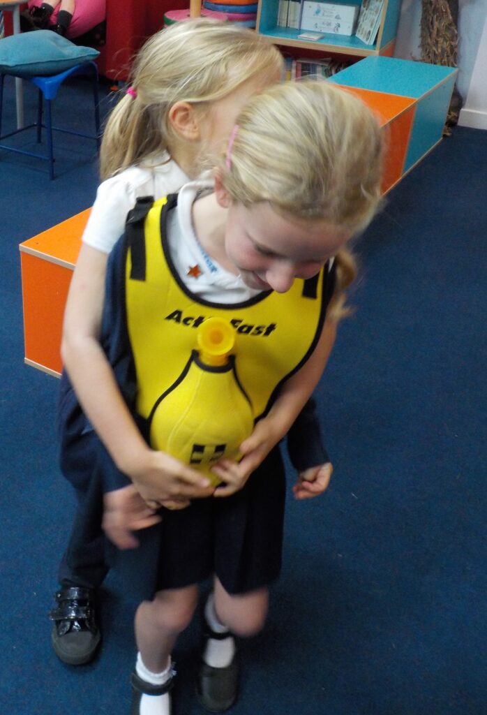 Children using Act Fast training vest to practice removing a blockage if someone else is choking.